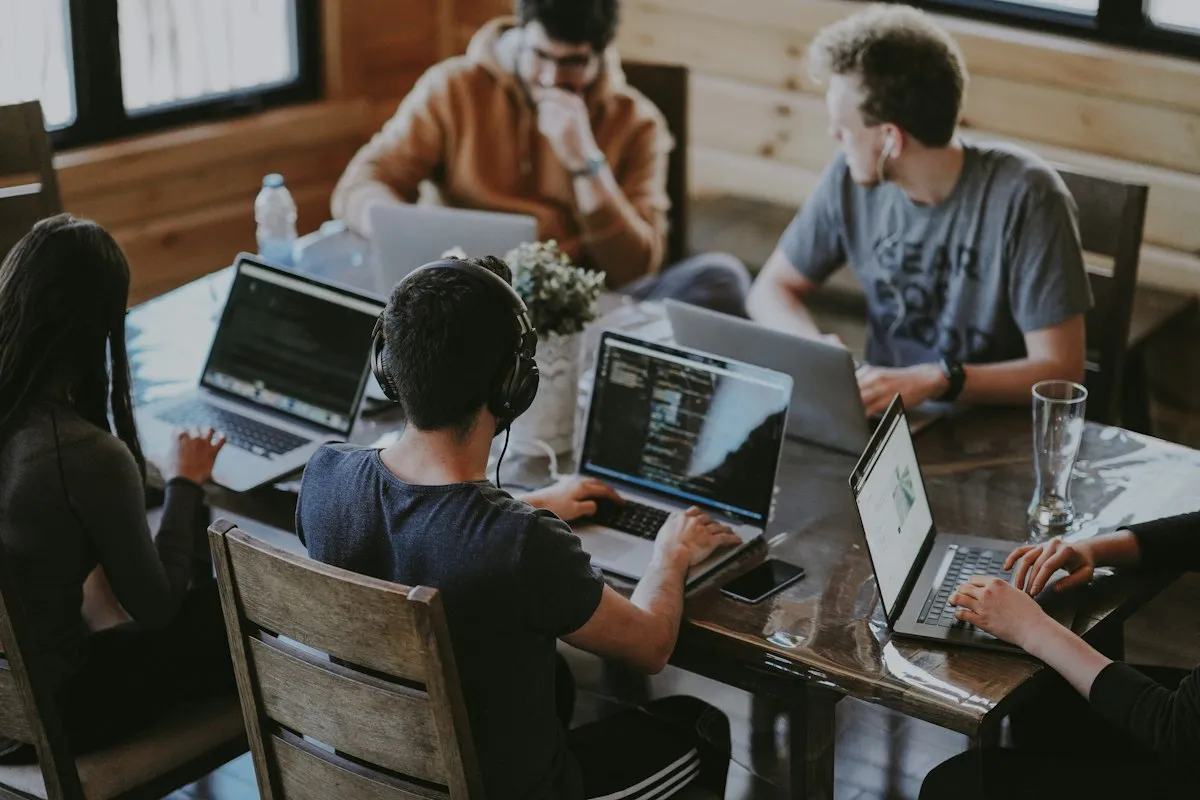 Equipo de jóvenes programando juntos, formación en talento IT y desarrollo de software a medida